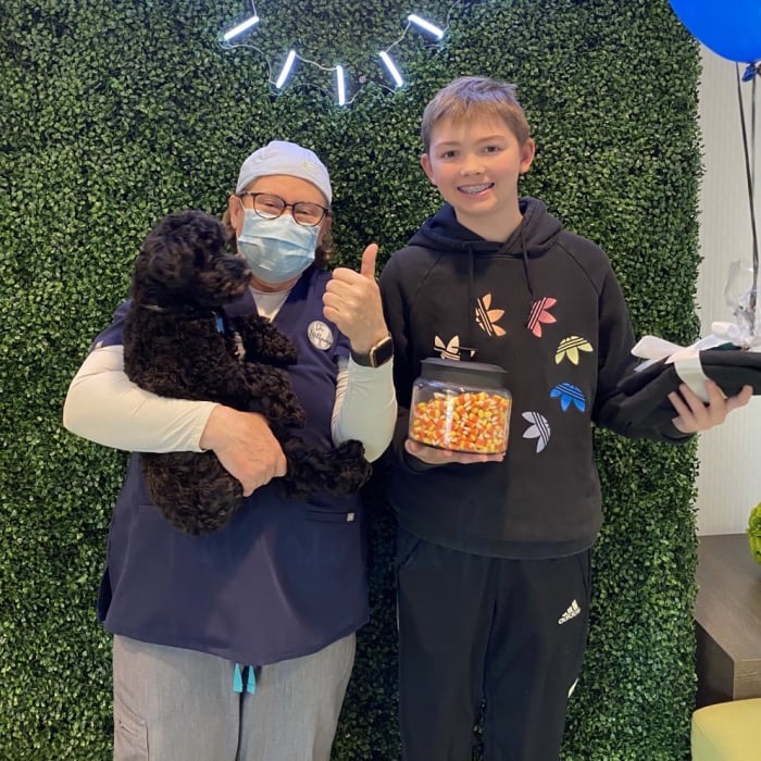 Dr. Lesley stands with a kid patient who is holding candy at South Surrey Smiles.