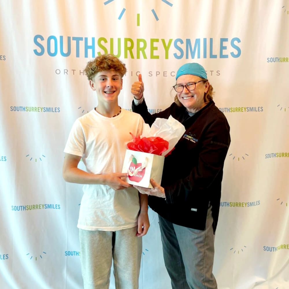 Dr. Lesley Williams smiles with a patient at Dr. Lesley Williams stands with a patient at South Surrey Smiles.
